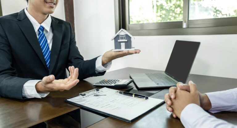 Agent immobilier expliquant les pourcentages de commission à un couple, graphique simple sur papier ou tablette