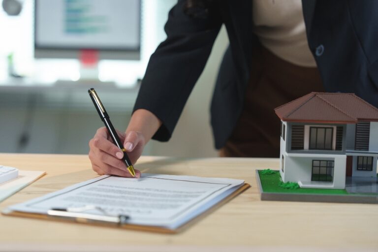 Salon d’une maison familiale préparé pour une visite, avec brochures d’agences sur la table