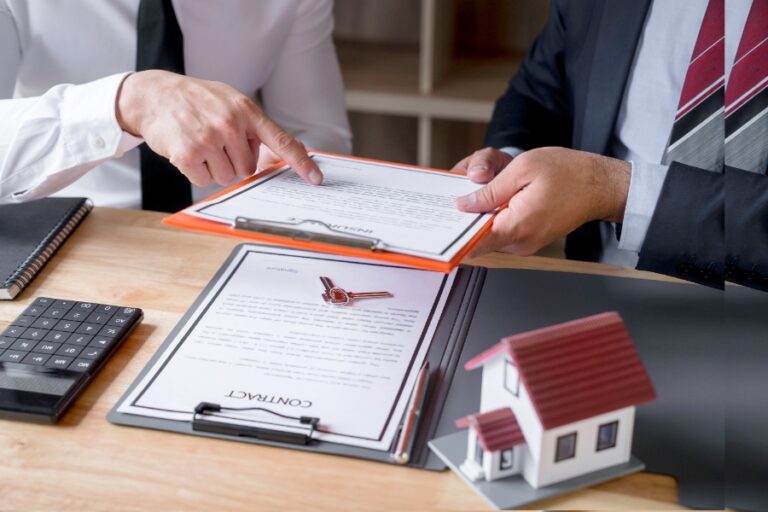 Pile de dossiers comprenant l’acte authentique de vente, soigneusement rangé dans une pochette cartonnée