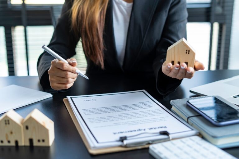 Billets et pièces de monnaie déposés sur un contrat de vente, représentant le règlement des frais notariés