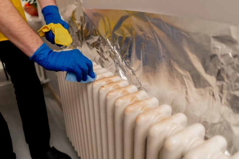 Main effectuant la purge d’un radiateur avec une clé de purge