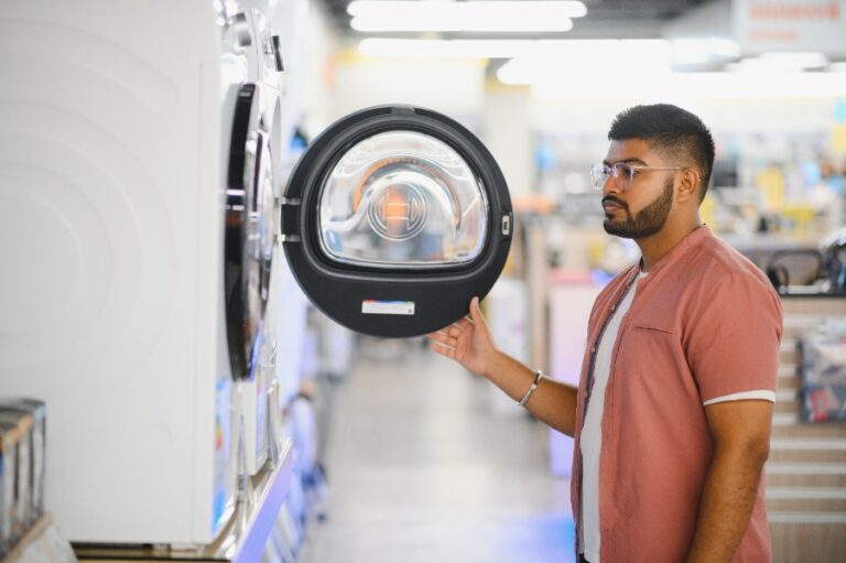Robinet d’arrivée d’eau d’une machine à laver avec une petite fuite visible sous le logement d’un locataire