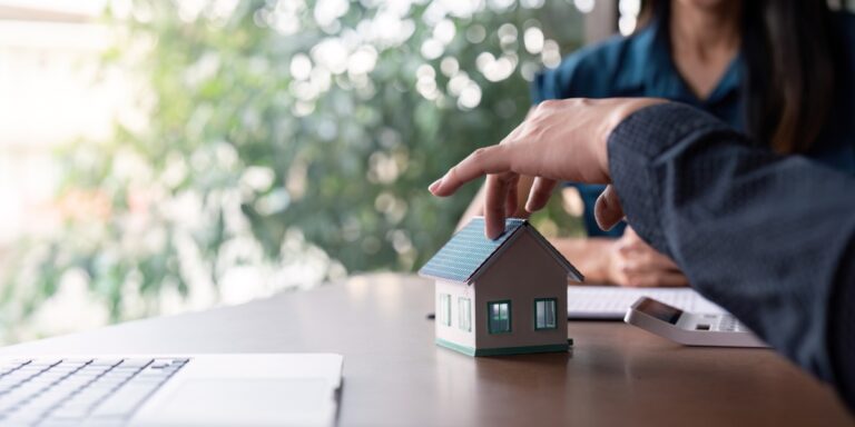 Un conseiller bancaire analyse un dossier de prêt immobilier et ajuste le taux proposé face à un client