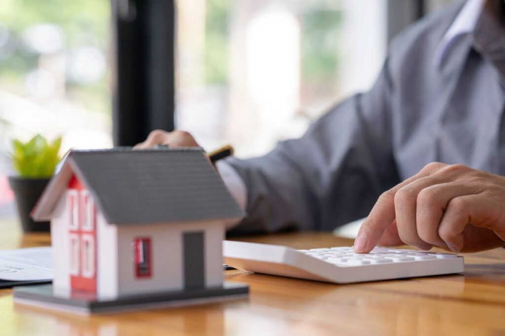 Un emprunteur de prêt immobilier qui utilise une calculatrice pour calculer son intérêt