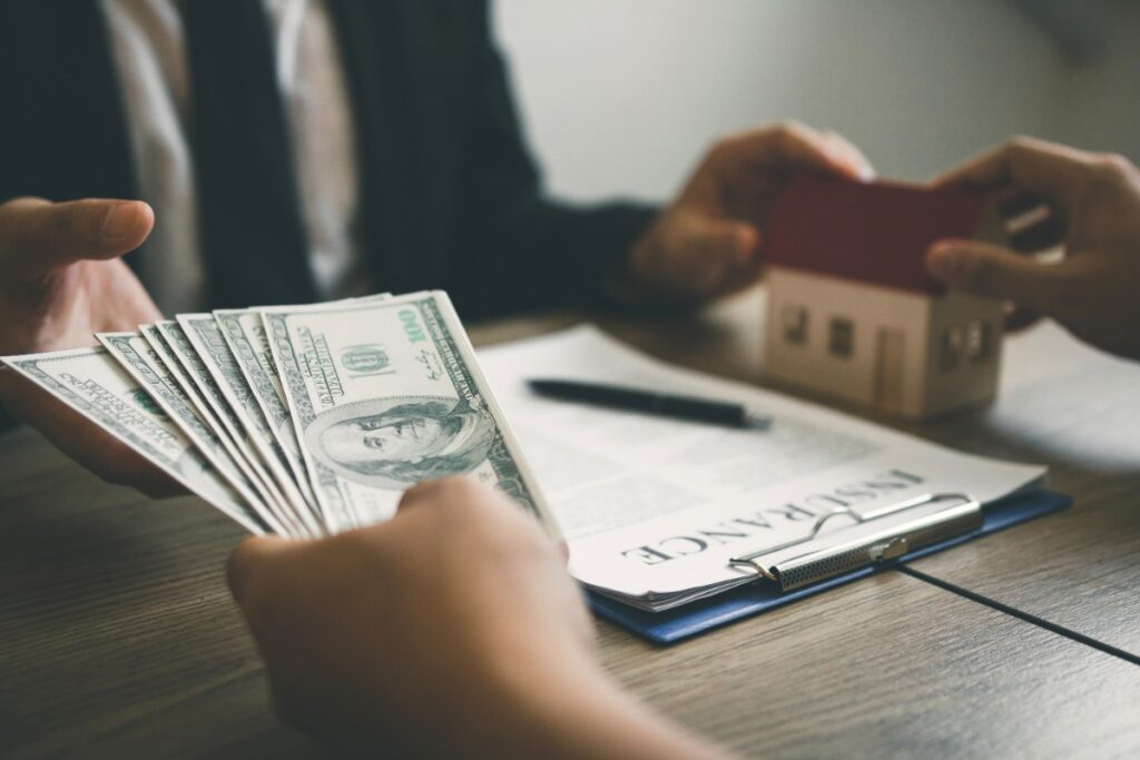 Une personne donnant de l'argent pour le remboursement de son prêt immobilier