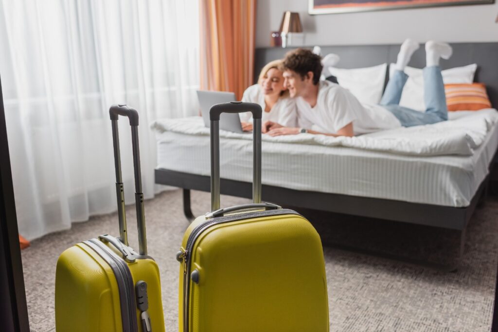Un couple qui discute sur le lit avec des bagages dans une chambre