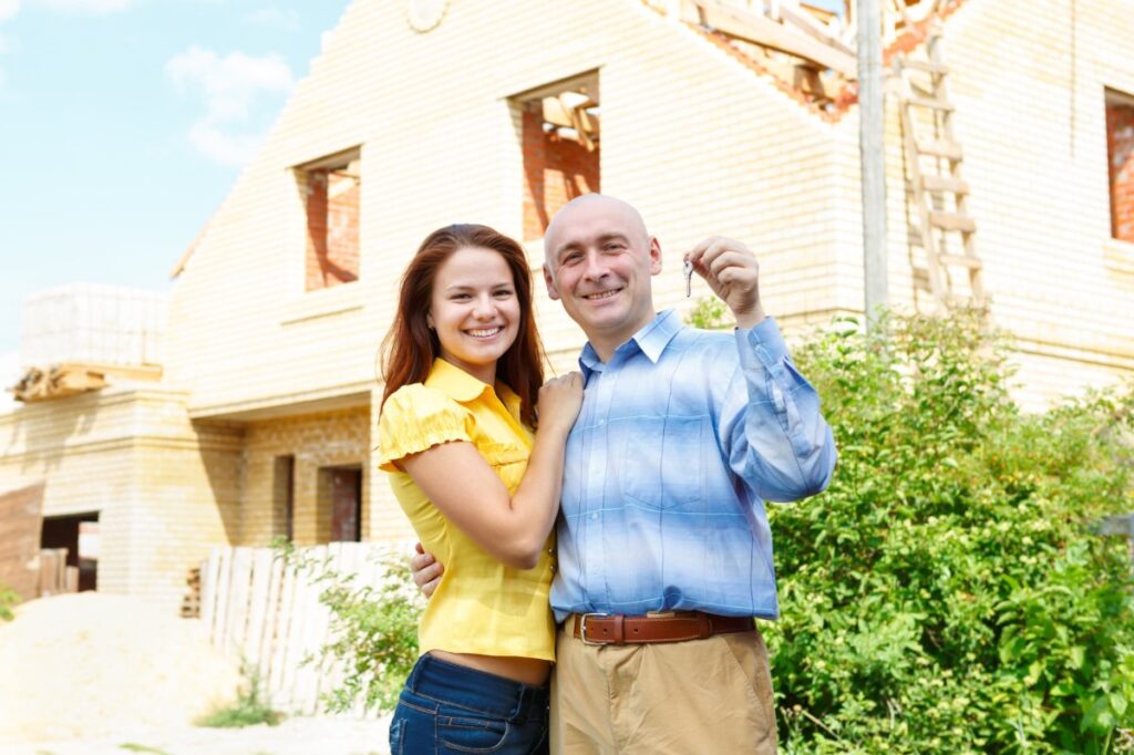 Un couple qui tient une clé d'une maison