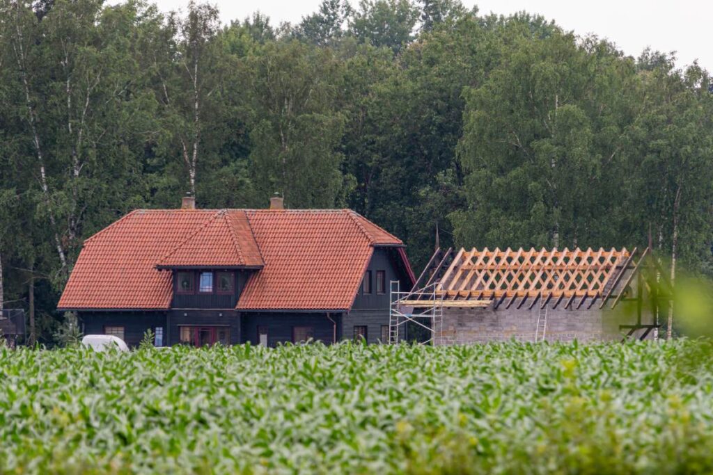 Une maison avec une nouvelle construction sur un terrain agricole