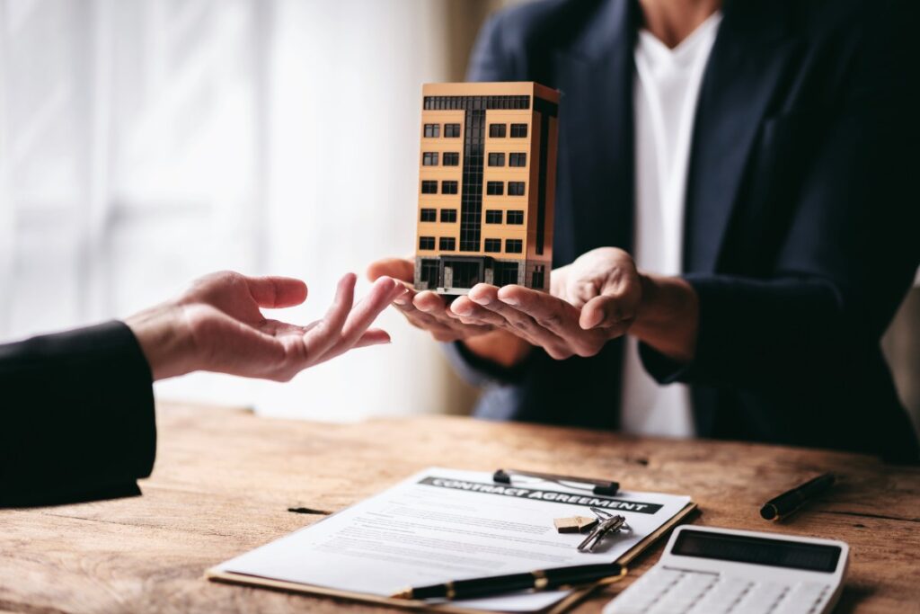Une personne qui tient une maquette de maison