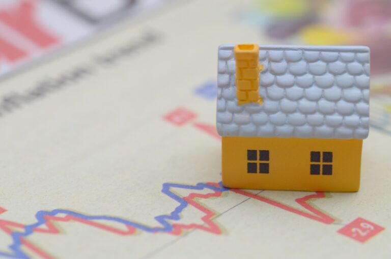 Une petite maison plancée sur un papier avec un graphique