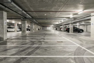 Parking souterrain moderne avec places délimitées et colonnes numérotées dans un immeuble résidentiel urbain