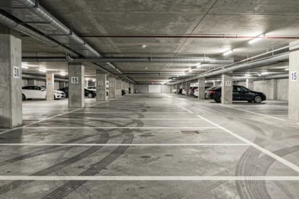 Parking souterrain moderne avec places délimitées et colonnes numérotées dans un immeuble résidentiel urbain